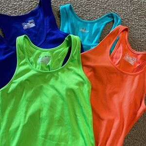 Four Under Armour tanks